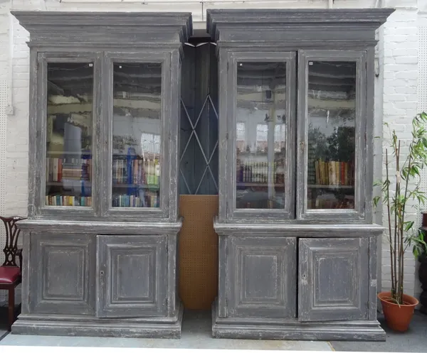 A pair of late 19th century distressed grey painted bookcase cabinets each with pair of glazed doors over panel cupboards, 116cm wide x 293cm high x 5