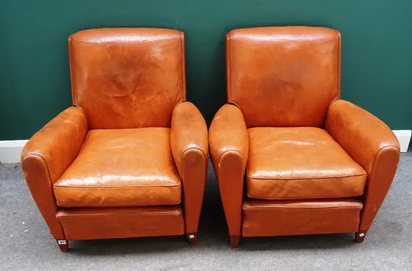 A pair of early 20th century French tanned leather easy armchairs on tapering square supports, 75cm wide x 81cm high (2).