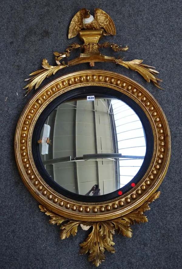 A Regency gilt framed convex wall mirror with eagle surmount and acanthus spray lower frieze, 64cm wide x 106cm high.