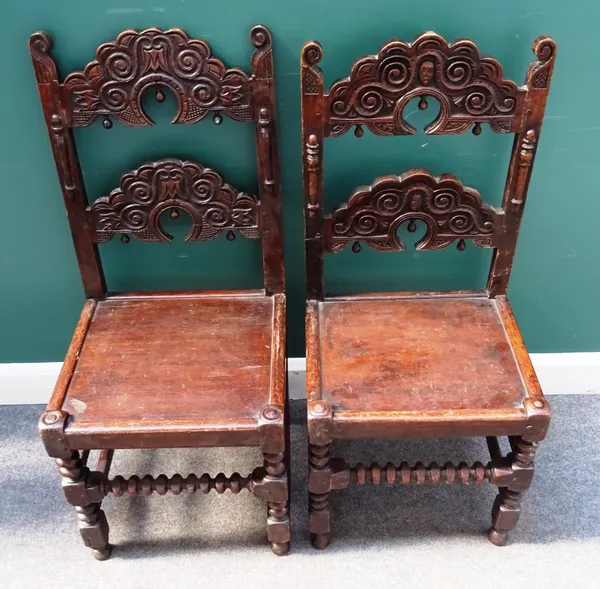 Two similar sets of four Charles II style oak dining chairs, with carved and shaped double ladder back, over solid seat, on block and turned supports,