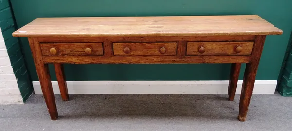 An early 19th century French waxed pine three drawer dresser base on tapering square supports, 186cm wide x 80cm high x 43cm deep.