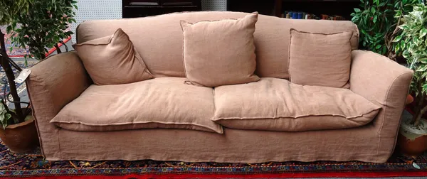 Conran; a 20th century sofa with loose tan cotton covers, 225cm wide x 85cm high x 43cm deep.