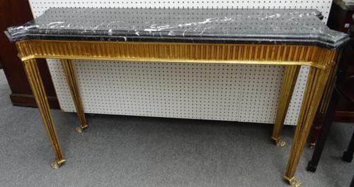 An 18th century style console table, the black marble top with stepped corners, on a gilt fluted base and metal lion's paw feet, 150cm wide x 85cm hig