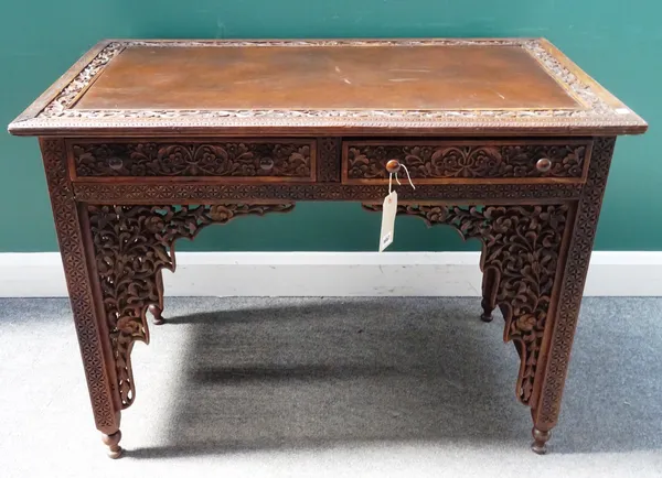 A 19th century Indian profusely carved and pierced hardwood two drawer writing desk, 105cm wide x 79cm high x 60cm deep.