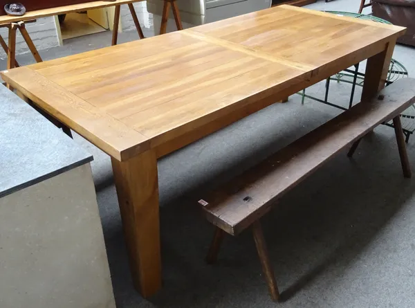 A 20th century oak extending dining table, the cleated plank top on tapering square supports, 100cm wide x 220cm long x 270cm fully extended.