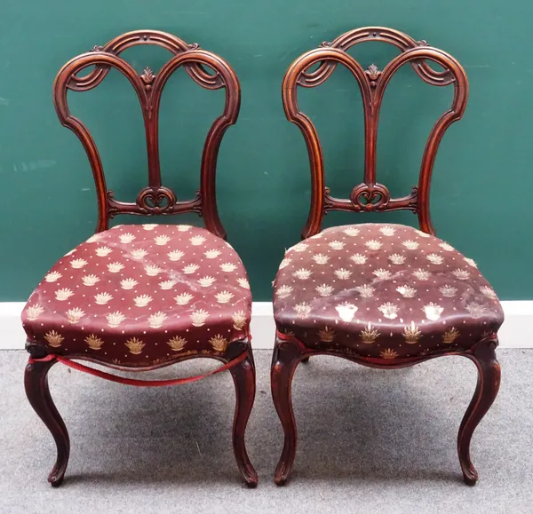 A set of six Victorian walnut framed dining chairs with interlaced back and serpentine seat on cabriole supports, (6).
