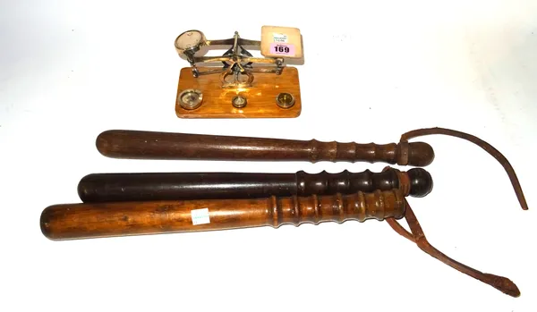 A set of early 20th century silvered metal postage scales and three turned wooden truncheons, (qty).  CAB