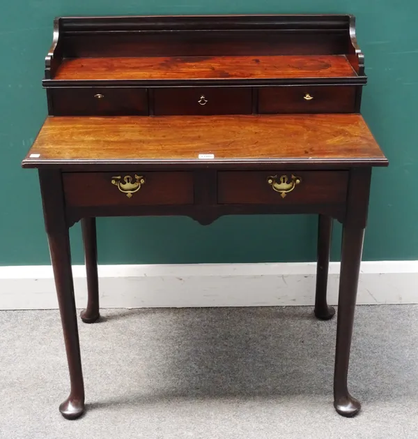 A George III mahogany writing table, the three drawer ledge back superstructure over a pair of frieze drawers on club supports, 79cm wide x 90cm high