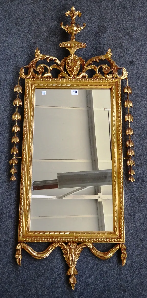 An 18th century French style gilt framed rectangular mirror with floral moulded crest and draped swag lower frieze, 56cm wide x 130cm high.