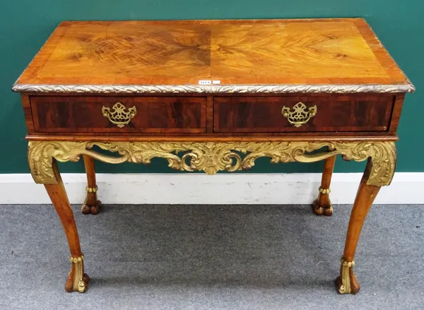 A George I style parcel gilt decorated figured walnut two drawer side table with pierced and carved frieze on knurl feet, 106cm wide x 79cm high x 55c