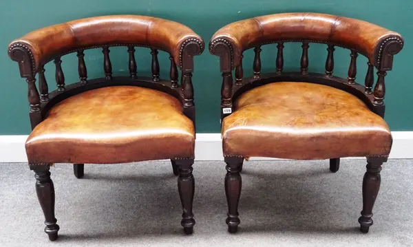 A pair of late 19th century brown leather upholstered tub back captain's chairs with baluster turned supports and serpentine seat, 63cm wide x 77cm hi
