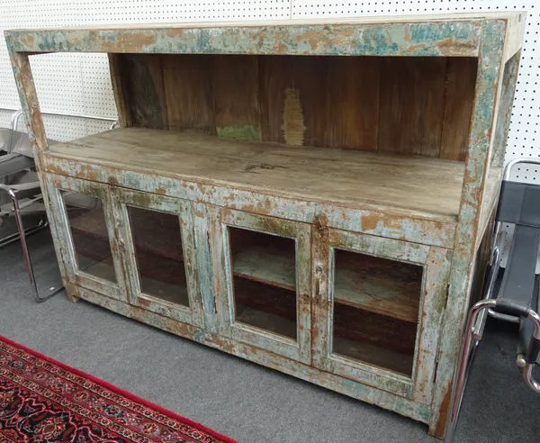 A distressed green painted hardwood side cabinet with two shelf tiers over four glazed doors on block feet, 170cm wide x 118cm high x 55cm deep.