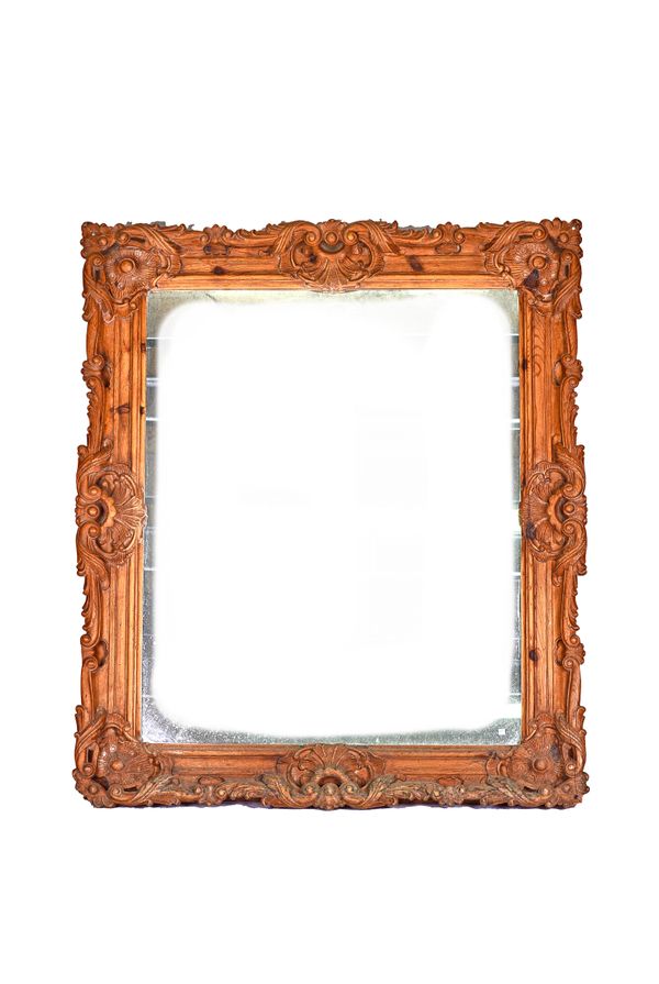 A large 19th century pine framed mirror with deep cut acanthus scroll carved frame, 140cm wide x 163cm high. Illustrated