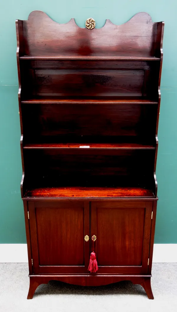 A George III mahogany waterfall bookcase cabinet, the enclosed three tier back over pair of panel cupboards on splayed bracket feet, 77cm wide x 161cm