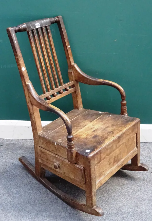 An early 19th century ash and fruitwood lambing rocking chair, the base with single side drawer, 52cm wide x 89cm high.Provenance; Property from Prude