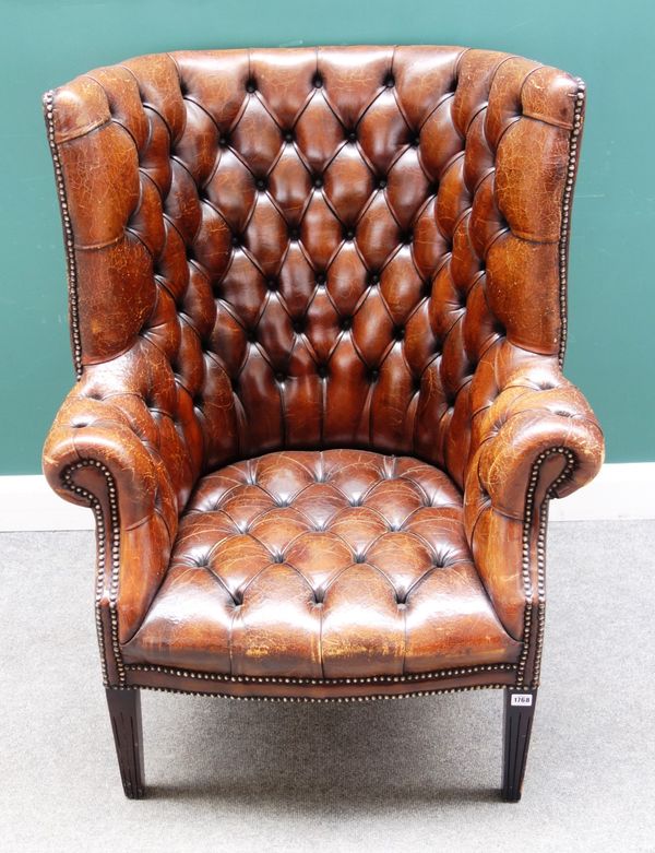 A George II style studded brown leather upholstered tub back easy armchair with rollover arms on tapering square supports, 85cm wide x 110cm high.