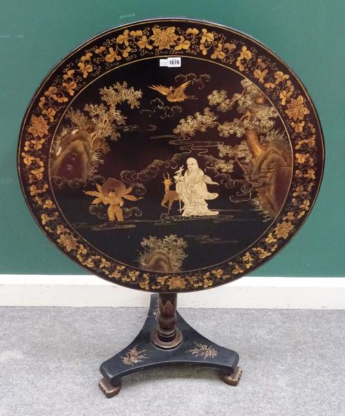 An early 19th century black lacquer chinoiserie decorated circular snap top occasional table, on turned column, with trefoil platform and gilt paw fee
