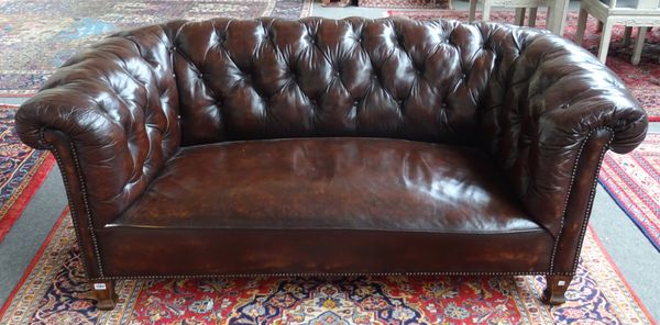 An early 20th century brown leather upholstered button back Chesterfield sofa on tapering square supports, 175cm wide x 70cm high.