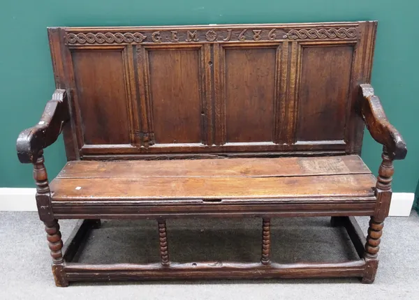 A made-up 17th century and later oak settle, with four panel back over solid seat on bobbin supports, 144cm wide x 104cm high.