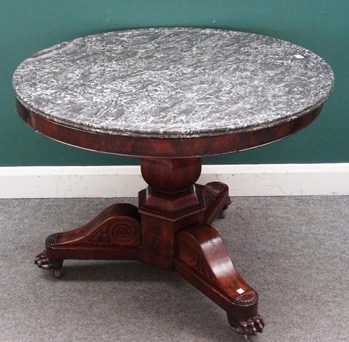 An early 19th century French gueridon, the circular marble top on a mahogany baluster octagonal column and three paw feet, 97cm diameter x 76cm high.
