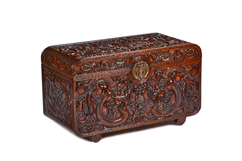 A late 19th/early 20th century Chinese hardwood trunk, extensively carved with dragons, 90cm wide x 53cm high x 43cm deep. Illustrated