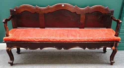 A 19th century French chestnut open arm bench with shaped triple panel back and solid seat on scroll supports, 185cm wide x 100cm high.