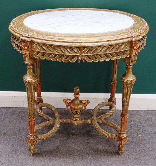 A 20th century centre table, the oval marble inset top on a carved polychrome painted base with four fluted supports united by urn mounted shaped stre