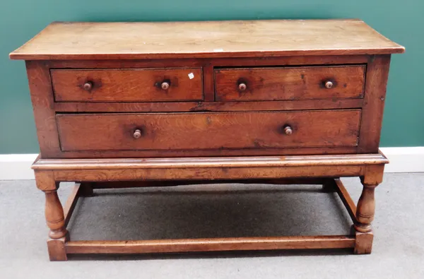 An 18th century oak side cabinet/ dresser base, with two short over one long drawer, on baluster turned supports, united by perimeter stretcher, 137cm