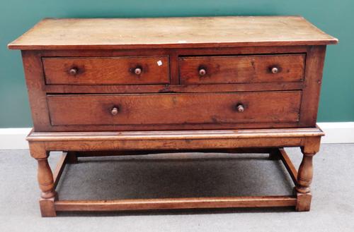 An 18th century oak side cabinet/ dresser base, with two short over one long drawer, on baluster turned supports, united by perimeter stretcher, 137cm
