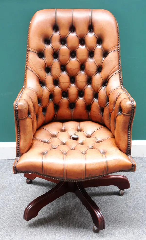 A 20th century studded button brown leather upholstered tub back office swivel chair on a five point base, 66cm wide x 114cm high.