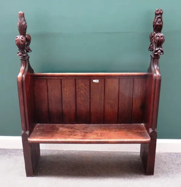 A small 19th century oak church pew with acanthus carved fleur-de -lys ends, reduced, 107cm wide x 144cm high.