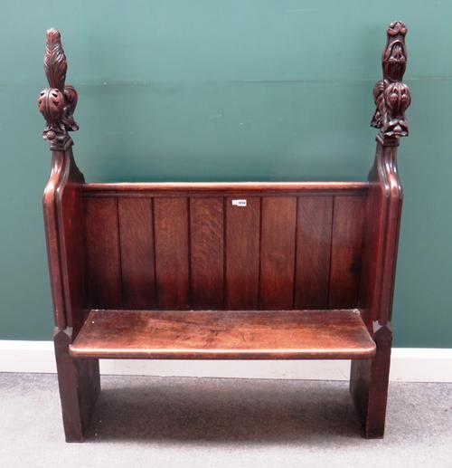 A small 19th century oak church pew with acanthus carved fleur-de -lys ends, reduced, 107cm wide x 144cm high.