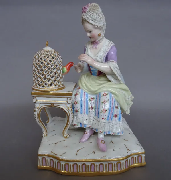 A Meissen porcelain figure of `Touch' , late 19th century, emblematic of one of the four senses, modelled with a seated lady with a bird in a domed ca