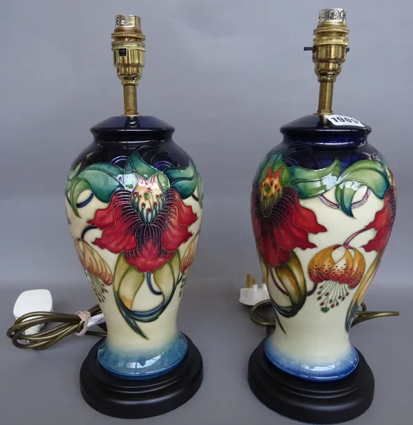 A pair of modern Moorcroft table lamps, decorated in the `Anna Lily' pattern,  wood bases, overall height including fittings, 40cm., (2).