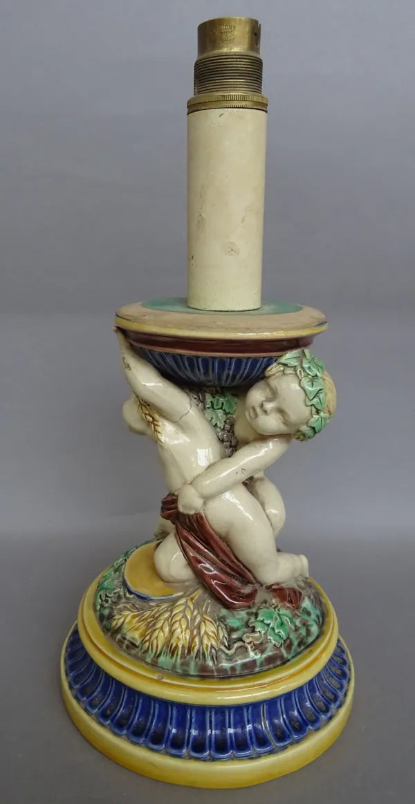 A Minton majolica table lamp base, late 19th century, moulded with putti  emblematic of the seasons on a fluted circular base, 18cm high. Provenance;