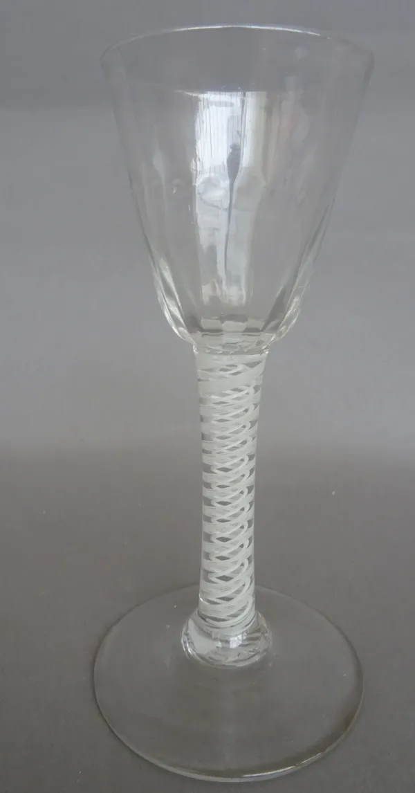 An opaque twist wine glass, circa 1765, the moulded rounded funnel bowl raised on a double- series opaque twist stem and plain foot, 14.5cm. high.