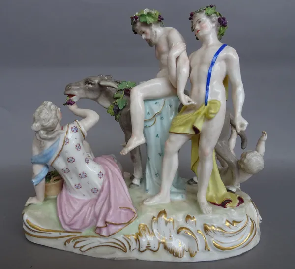 A Paris porcelain group of drunken Silenus, late 19th century, after a Meissen original, modelled seated on the back of a donkey with attendants, blue