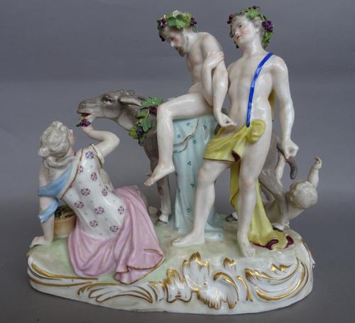 A Paris porcelain group of drunken Silenus, late 19th century, after a Meissen original, modelled seated on the back of a donkey with attendants, blue