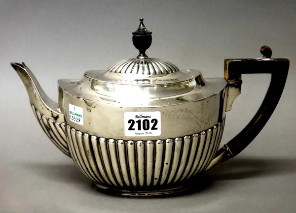 A Victorian silver teapot, of oval form, with partly fluted decoration and with ebonised fittings, London 1894, gross weight 532 gms.