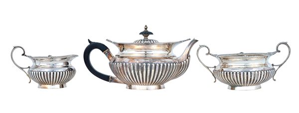 A late Victorian silver three piece tea set, comprising; a teapot, a twin handled sugar bowl and a milk jug, each piece with partly fluted decoration