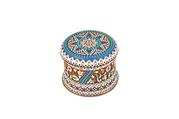 A Russian style gilt and polychrome shaded cloisonne enamelled hinge lidded box, of cylindrical form, with floral and scrolling decoration, raised on