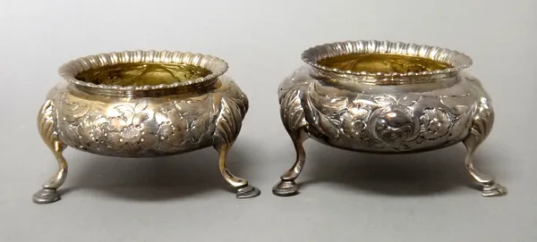 A pair of Victorian silver salts, each of circular form, with floral and foliate embossed decoration, raised on three feet, London 1862, combined weig