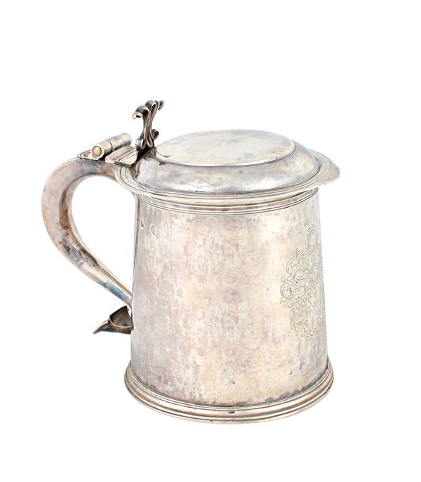 A Charles II silver hinge lidded tankard, of tapering cylindrical form, the hinged scrolling handle pin pricked with initials within scrolling borders