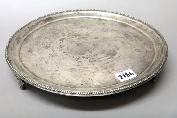 A Spanish circular salver, decorated with a beaded rim, raised on three shaped feet, decorated with quatrefoils and with beaded terminals to the feet,