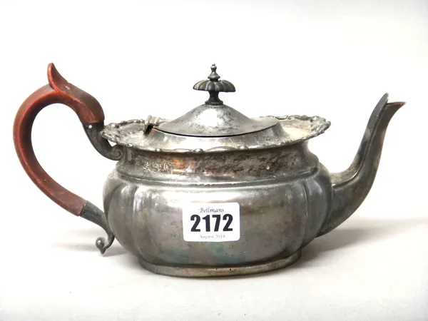 A silver teapot of oval form, having a scrolled border to the shaped rim, with composition fittings, Birmingham 1907, gross weight 405 gms.