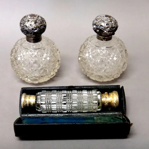 A Victorian silver gilt mounted, double ended octagonal faceted glass smelling salts cum scent bottle, with feathered scroll engraved decoration, Lond