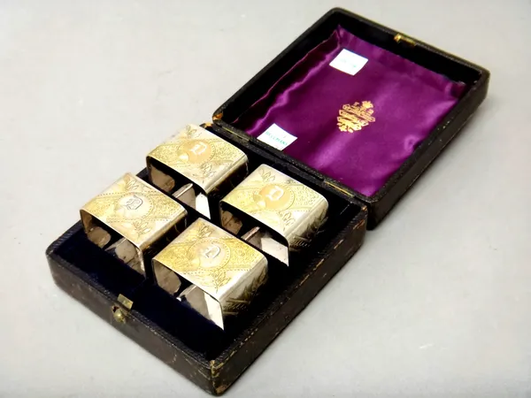 A set of four Victorian silver plated and partly gilt napkin rings, each of square form, engraved in the Aesthetic Movement taste and with the initial