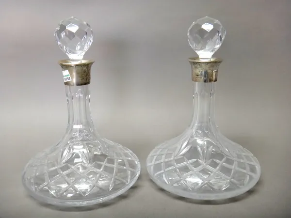 A pair of silver mounted moulded glass ship's decanters, on circular bases, height 26.5cm.