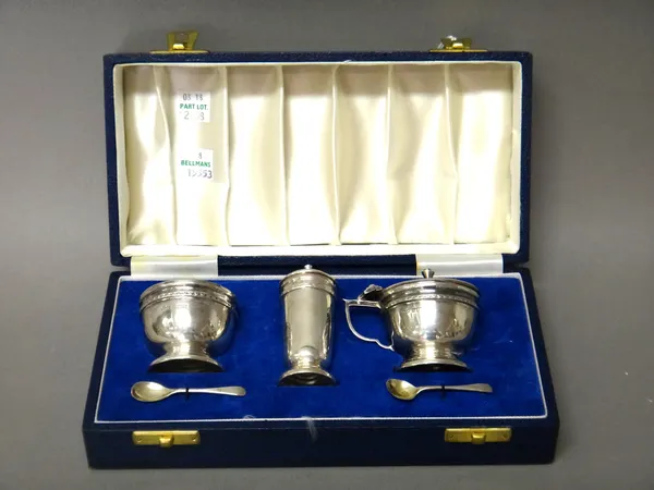 A silver three piece composite condiment set, comprising; a mustard pot, a salt, a pepperette and two condiment spoons, each piece of circular form, h