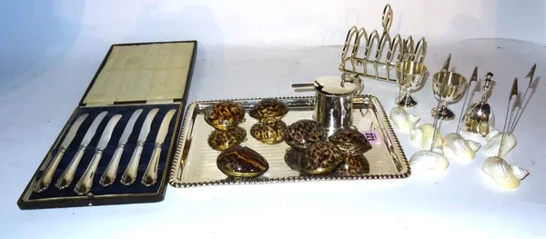 Silver plated wares, including; a small rectangular plated tray, toast rack, egg cups, menu stands and sundry, (qty).   CAB